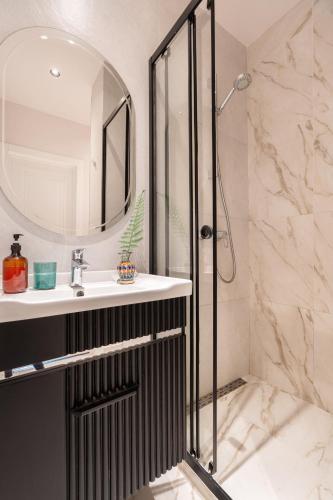 a bathroom with a shower and a sink and a mirror at Blueloft 65 I Apartment with Balcony and City View in Tashkent