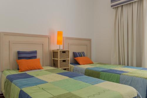 ヴィラモウラにあるAkisol Vilamoura Soft IIIのベッドルーム1室(隣り合わせのベッド2台付)