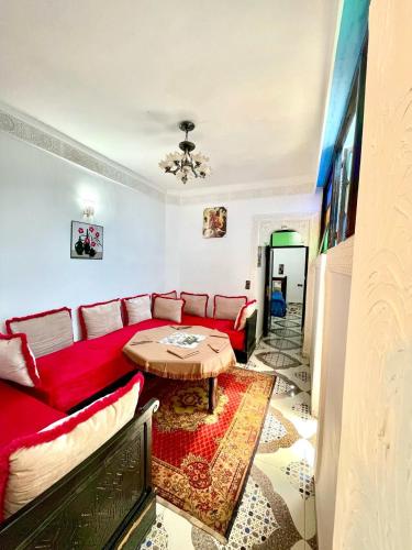 a living room with a red couch and a table at Blue Star Hostel in Fez