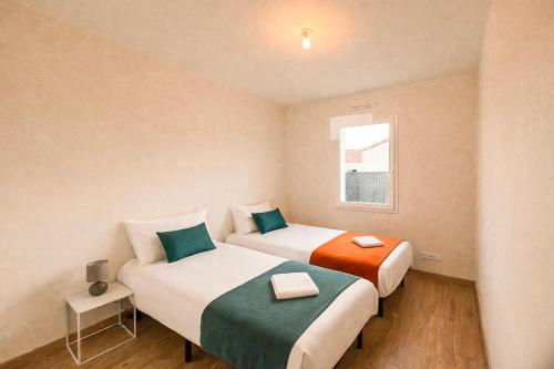 two beds in a small room with a window at Maison 5-6 personnes -15 min du Parc - Parking -by R&G in La Pommeraie-sur-Sèvre