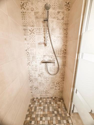 a shower with a shower head in a bathroom at Maison 5-6 personnes -15 min du Parc - Parking -by R&G in La Pommeraie-sur-Sèvre