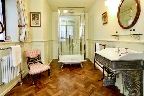 a bathroom with a shower and a sink and a tub at Llangattock Park House in Crickhowell