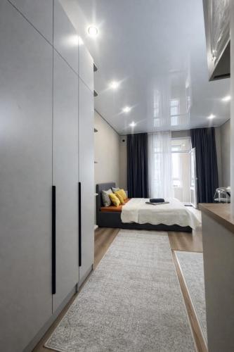 a bedroom with a bed and a large window at Современный апартамент Tandau в центре in Almaty
