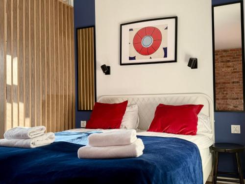 a bedroom with a blue and white bed with red pillows at Przy Ratuszu Idealny dla par Dzikie wino by Rentoom in Toruń