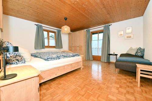 a bedroom with a bed and a couch in it at Ferienhof Kopf in Mäder