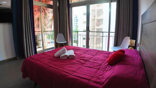 a bedroom with a pink bed with shoes on it at Apartalux Vera Rincón de Loix in Benidorm