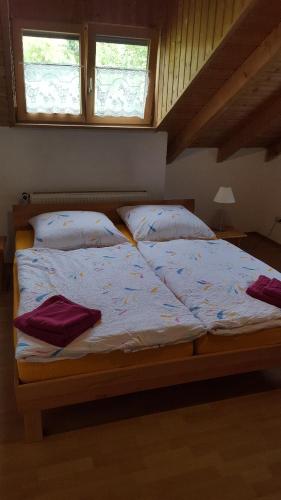 a bed with white sheets and pillows in a bedroom at Gästehaus Cavallo in Achberg