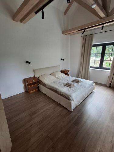 a bedroom with a bed and a wooden floor at Merino vendégház in Tiszabecs