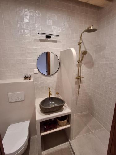 a bathroom with a sink and a toilet and a mirror at Merino vendégház in Tiszabecs