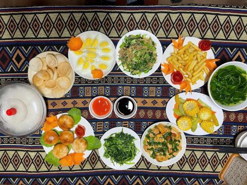 a table with plates of food on a table at Đoàn Kết Homestay in Dồng Văn