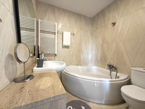 a bathroom with a tub and a toilet and a sink at Secret Spot Apartment - Quinta da Barca in Esposende