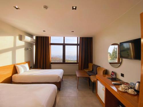 a hotel room with two beds and a television at Elite Marmara Bosphorus Çamlıca in Istanbul