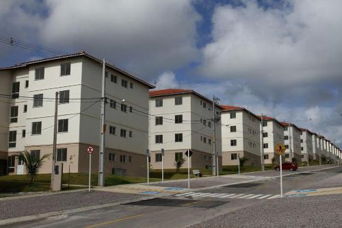 a row of white apartment buildings on a street at Apt 2 quartos- Leia sobre a propriedade in Itamaracá