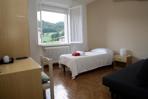 a small bedroom with a bed and a window at Vesta in Gargnano