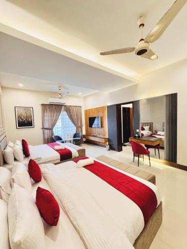 a bedroom with three beds with red pillows at Holiday One Hotel & Suites - DHA-8 in Karachi