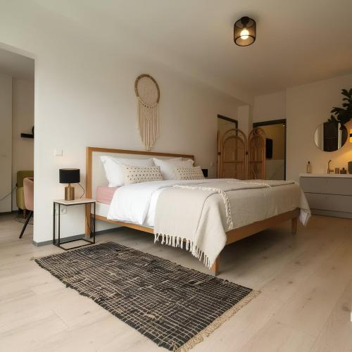 a bedroom with a large bed and a rug at The West Wing Bloemendaal in Bloemendaal