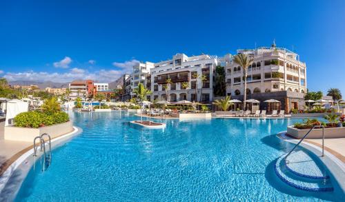 a large swimming pool in a resort with buildings at Gran Tacande Wellness & Relax Costa Adeje in Adeje