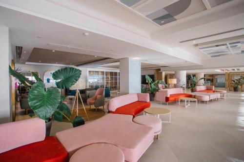 a waiting room with pink furniture and plants at Hotel Cristina by Tigotan Las Palmas - Adults Only in Las Palmas de Gran Canaria