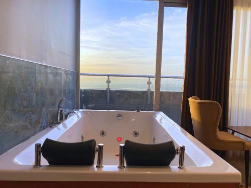 a bath tub in a room with a large window at Elite Marmara Bosphorus Çamlıca in Istanbul