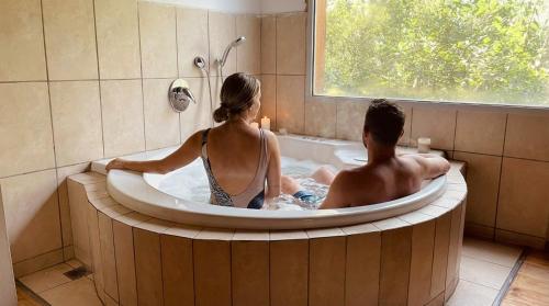 a man and woman sitting in a bath tub at Nofey HaBashan Country Lodge in Lahavot HaBashan