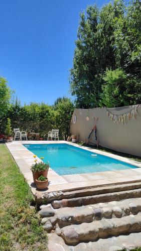 a swimming pool in a yard with a stone wall at Hospedaje de Barro in La Consulta