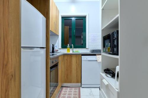 a kitchen with white appliances and wooden cabinets at Plaza House Ílhavo in Ílhavo