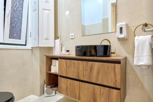 a bathroom with a wooden cabinet with a sink at Plaza House Ílhavo in Ílhavo