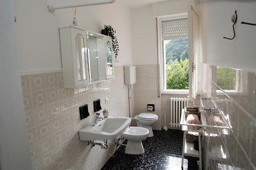 a bathroom with a sink and a toilet and a window at Vesta in Gargnano