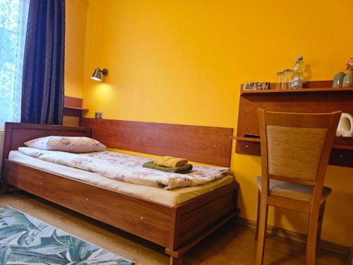 a small bedroom with a bed and a chair at POD ORŁEM in Wałcz
