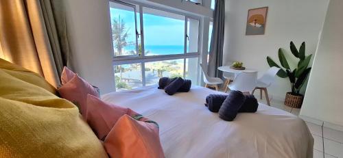 a bedroom with a bed with a large window at tiki tides in Umdloti