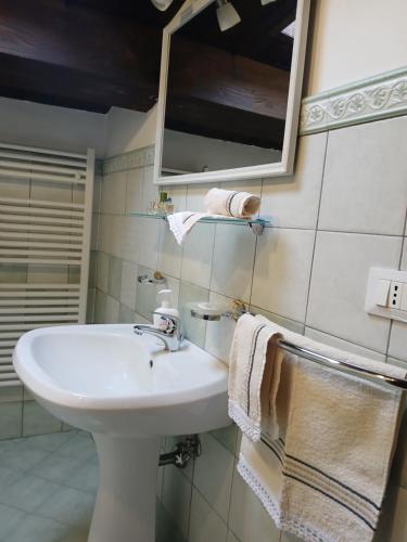 a bathroom with a sink and a mirror and towels at Le stanze di NinFa in Pacentro