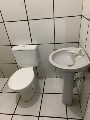 a bathroom with a toilet and a sink at Hotel economic in Sorocaba