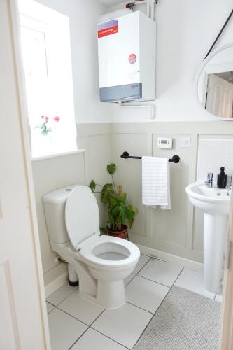 a white bathroom with a toilet and a sink at 4 bedroom, Sleeps 12, Free Parking in Corby and Weldon