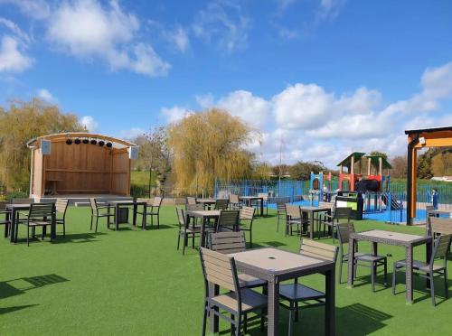 a group of tables and chairs with a playground at Sylvia's Sunrise Caravan Skegness Southview in Winthorpe