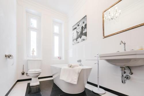 a white bathroom with a sink and a toilet at Golf Apartment Villa Elisabeth in Mariánské Lázně