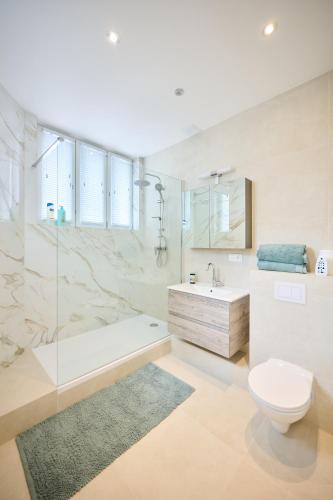 a bathroom with a tub and a toilet and a sink at Louise City 2 in Brussels