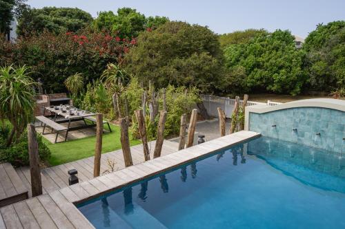 a swimming pool in a garden with a table and a bench at The Oyster Shack by The Oyster Collection in Kenton on Sea