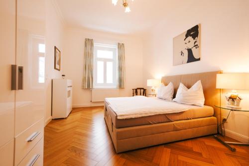 a small bedroom with a bed and a refrigerator at Golf Apartment Villa Elisabeth in Mariánské Lázně