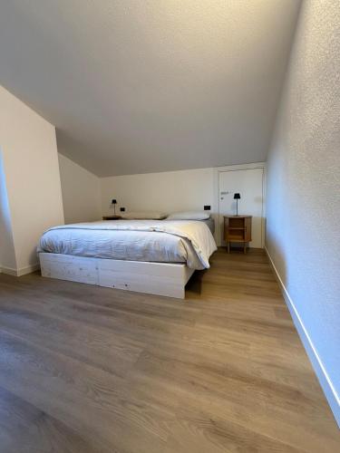 a bedroom with a bed and a wooden floor at Beato Mario Apartments in Tirano