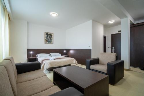 a hotel room with a bed and two chairs at Hotel Golf Luxury in Kruševac