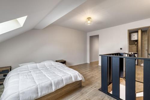 a white bedroom with a bed and a desk at Duplex design avec balcon I Hyper centre Thonon in Thonon-les-Bains