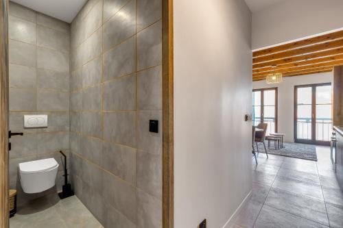 a bathroom with a toilet and a hallway at Duplex design avec balcon I Hyper centre Thonon in Thonon-les-Bains
