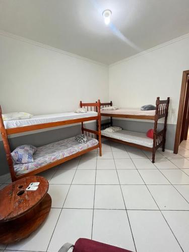 a room with two bunk beds and a table at HOSTEL SERUSSI in Balneário Camboriú