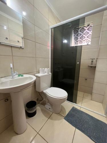 a bathroom with a toilet and a sink and a shower at HOSTEL SERUSSI in Balneário Camboriú