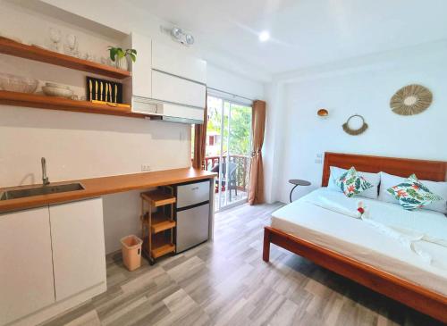 a bedroom with a bed and a sink and a kitchen at CiNta Hotel in Boracay