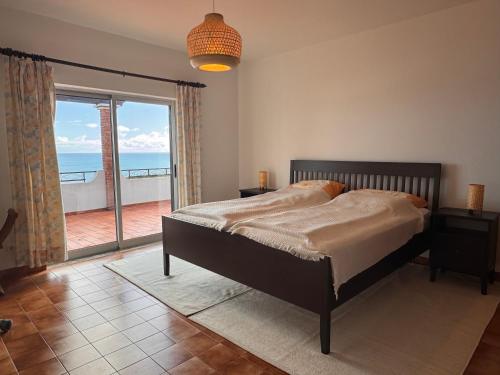 a bedroom with a bed with a view of the ocean at Casa Panorama in Salema