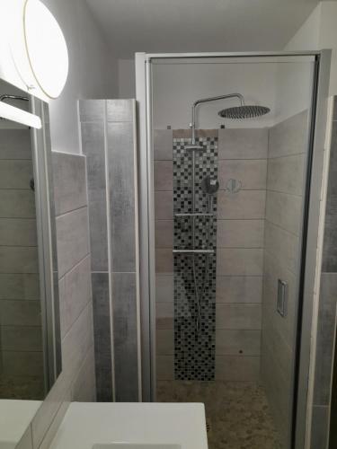 a bathroom with a shower with a glass door at Studio Cabine Sète Corniche Vue Mer 1ère ligne in Sète