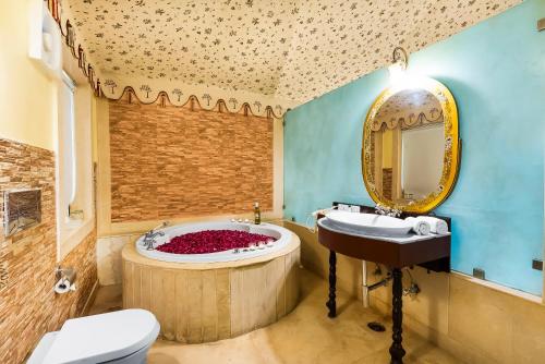 a bathroom with a tub with a sink and a toilet at Rajasthali Resort & Spa in Jaipur