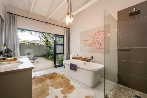 a bathroom with a tub and a shower and a sink at Ocean Breeze by The Oyster Collection in Kenton on Sea