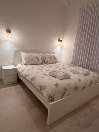 a white bed with two towels on it in a bedroom at בצל האורן Betzel haoren in El-Rom